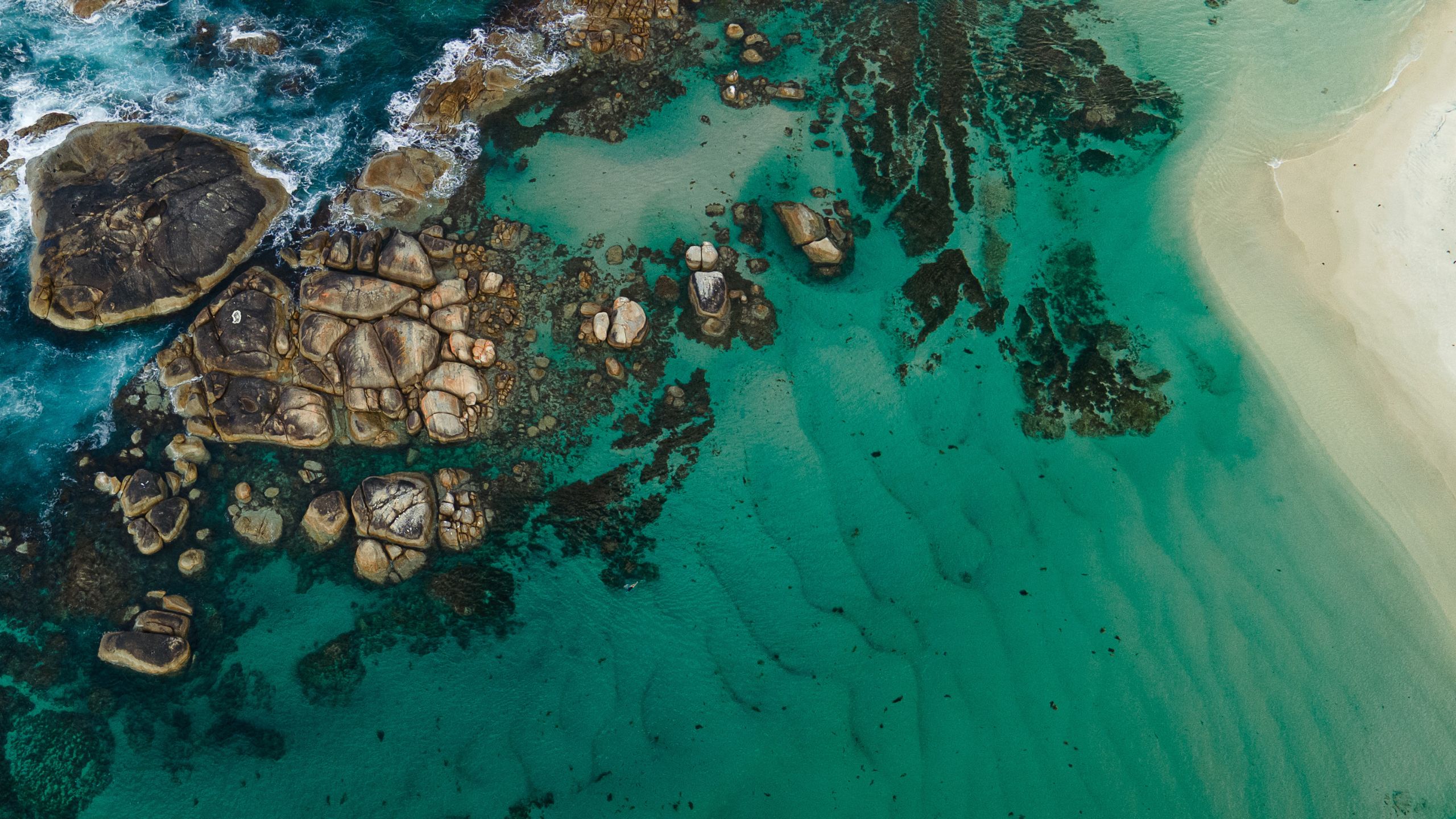 Aerial drone view of Greens Pool, William Bay National Park, Western Australia — emerald-green water bordered by smooth granite boulders.