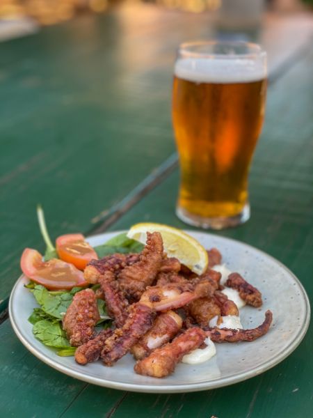 Fresh seafood paired with cold beer served at Finlay’s Restaurant in Kalbarri, Western Australia, showcasing a vibrant coastal dining experience