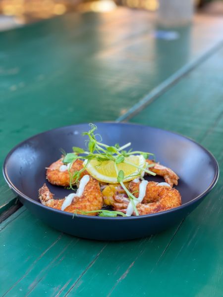 Golden crumbed prawns served with dipping sauce at outdoor seating of Finlay’s Restaurant in Kalbarri, Western Australia