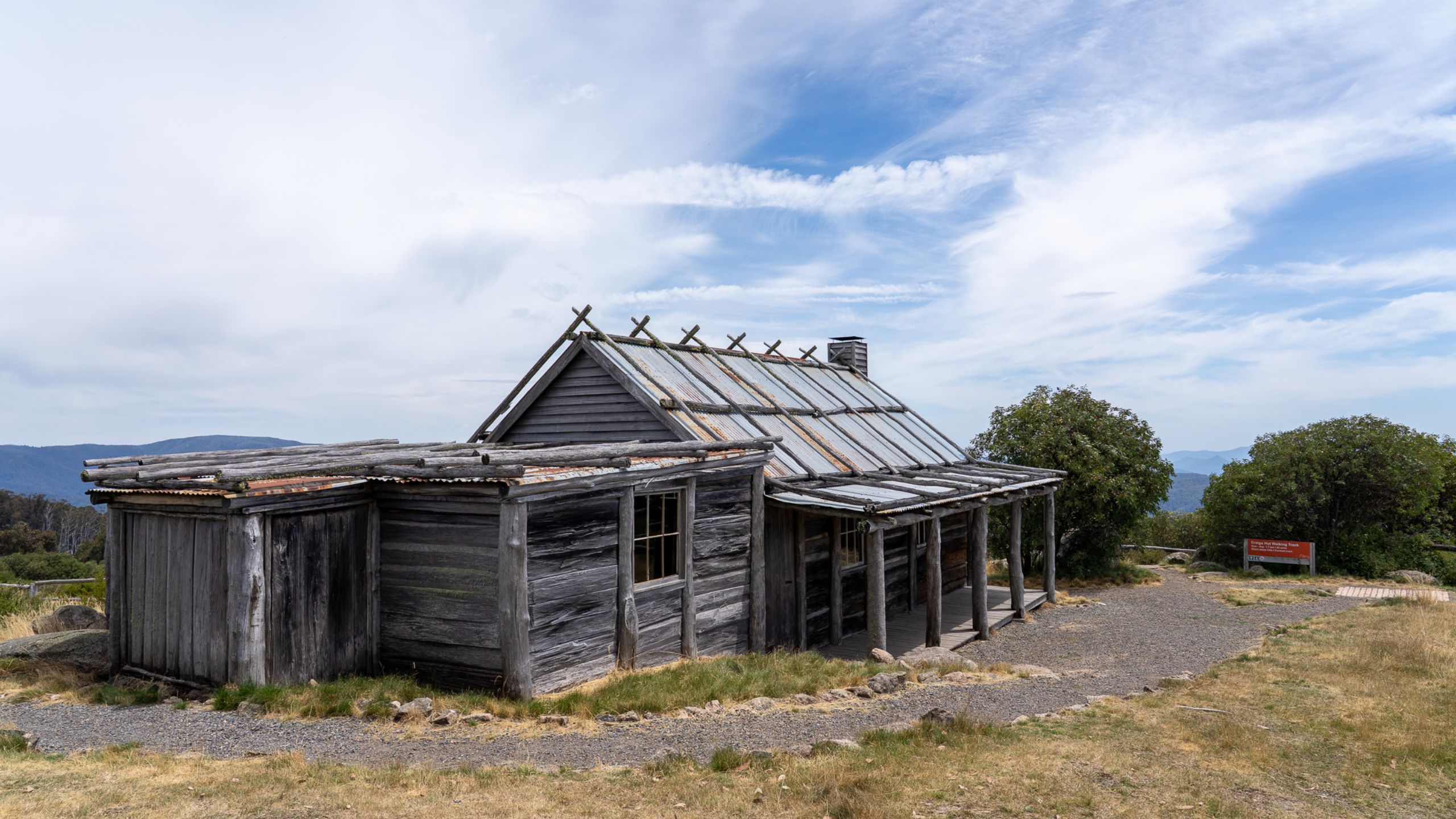 Craig’s Hut in the foreground with expansive views over the surrounding alpine valley and distant peaks.