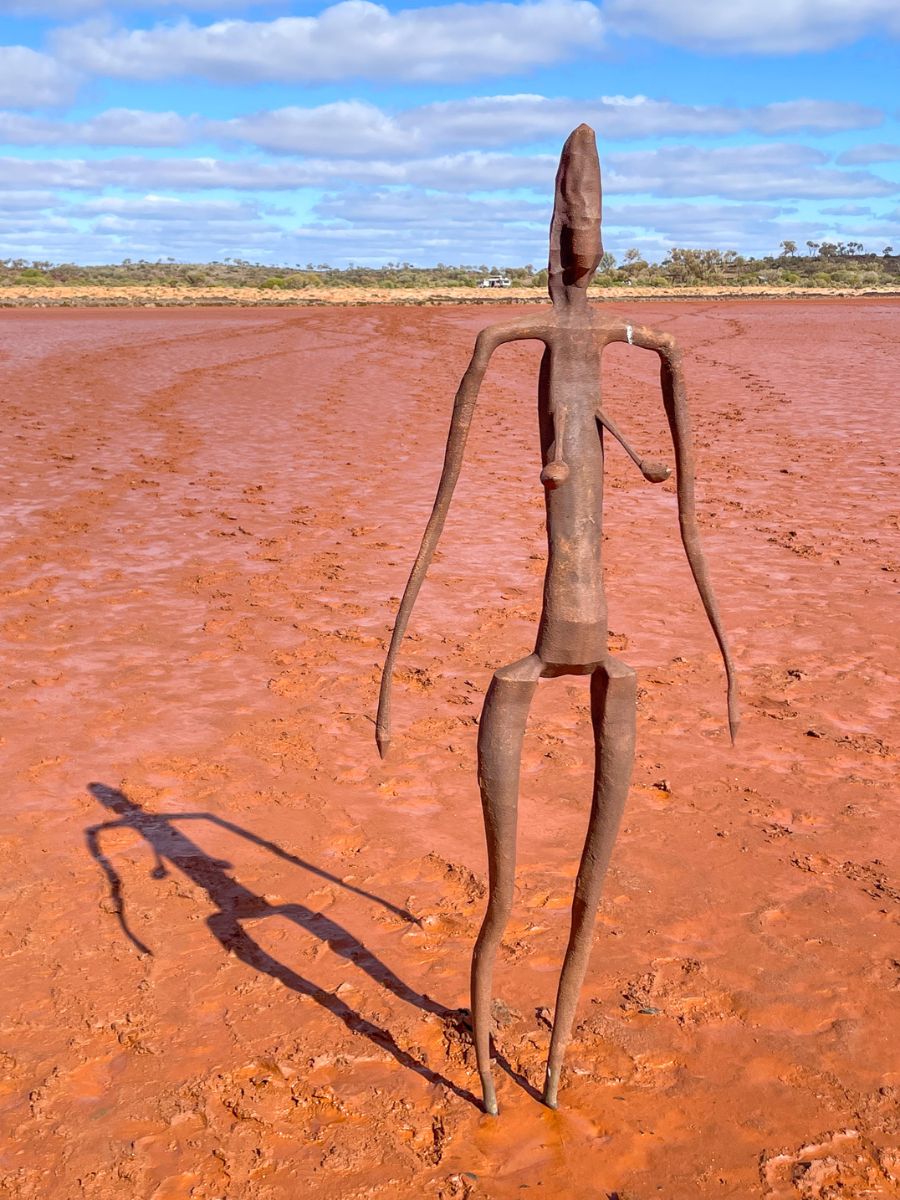 A female figure sculpture from Antony Gormley’s "Inside Australia" installation stands partially sunken in the muddy salt flats of Lake Ballard, Western Australia.