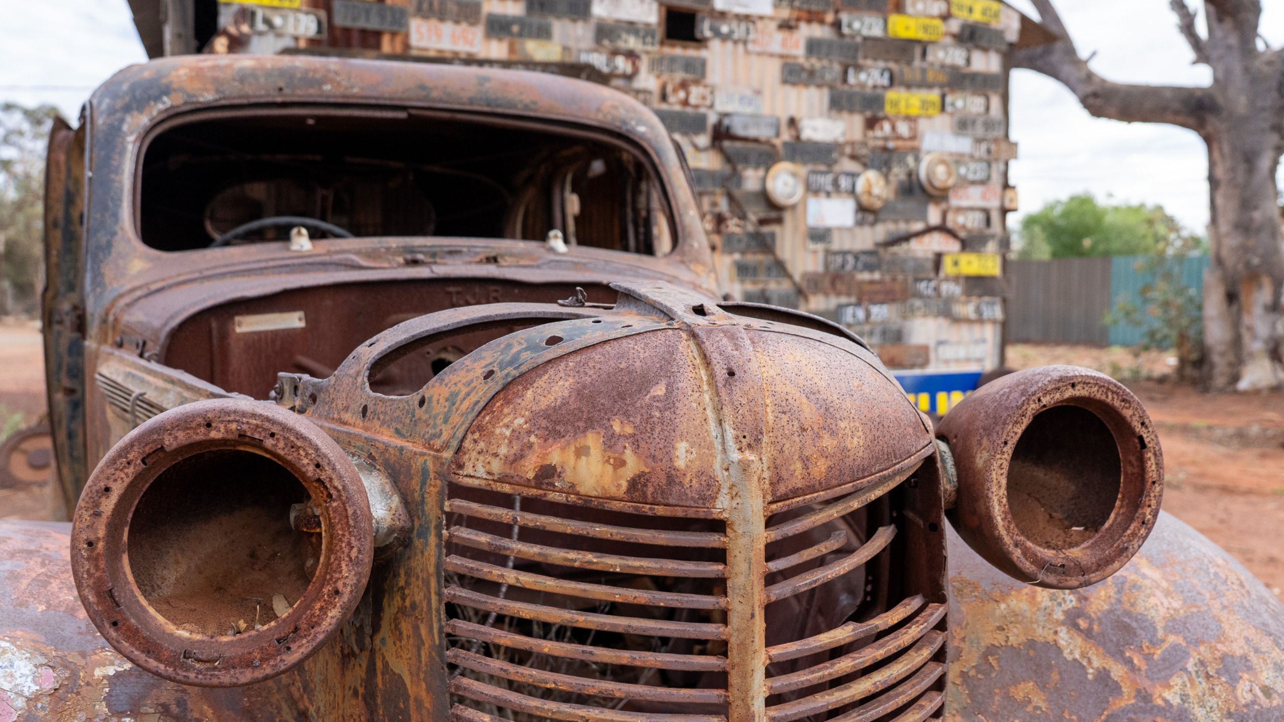 Rusted vintage car outside mechanic’s workshop in Gwalia, Western Australia