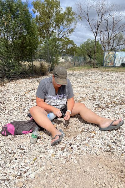 Woman trying her luck at opal fossicking in Lightning Ridge, New South Wales, a popular outback mining experience.